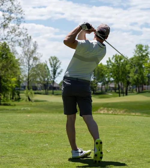 Un golfeur effectuant un coup de départ sur un terrain de golf.